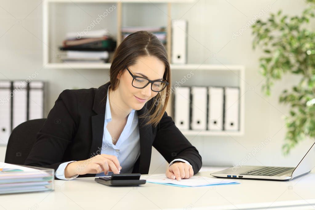 Office worker wearing eyeglasses doing accounting on a desk