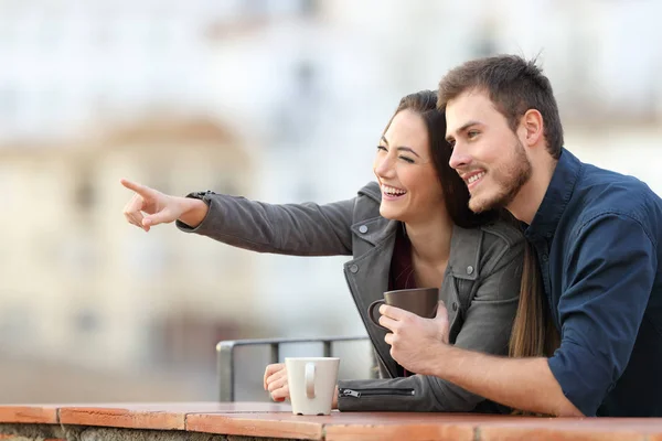 Glückliches Paar Zeigt Auf Einen Balkon Mit Einer Stadt Hintergrund — Stockfoto