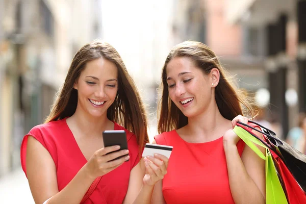 クレジット カードと通りを歩いて携帯電話オンラインで購入 つの幸せな買い物客の正面図 — ストック写真