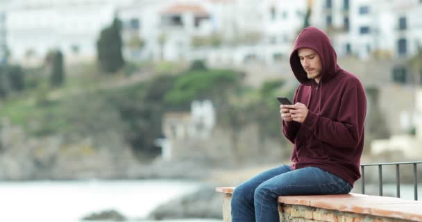 Vážnou Dospívající Textové Zprávy Telefonu Koukal Obzoru Sedí Římse Pláž — Stock video