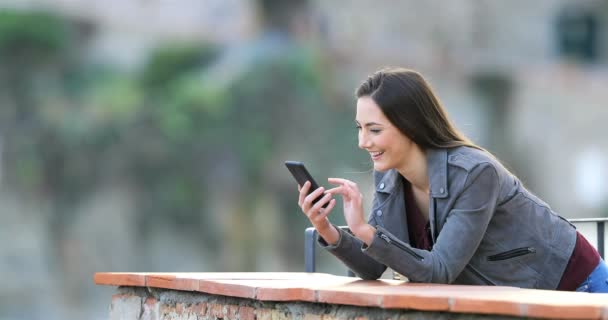 Mujer Feliz Navegando Por Contenido Del Teléfono Inteligente Una Terraza — Vídeos de Stock