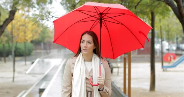 Retrato Una Mujer Seria Caminando Sosteniendo Paraguas Rojo Bajo Lluvia — Vídeo de stock