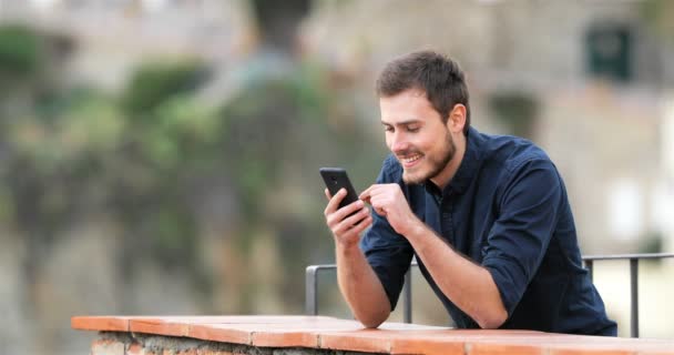 Uomo Eccitato Trovare Contenuti Online Uno Smartphone Una Terrazza Appartamento — Video Stock