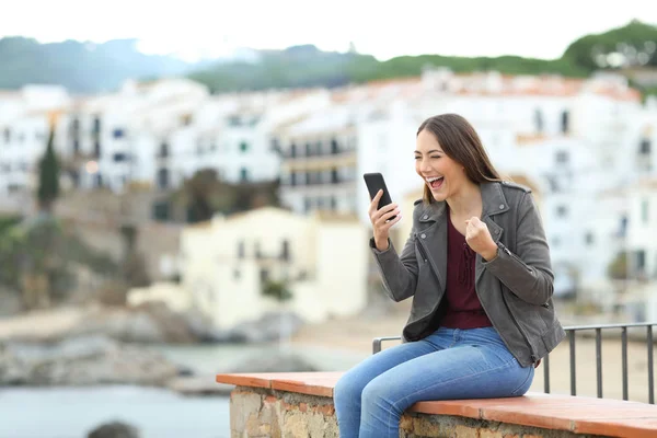 Excited Woman Checking Smart Phone Content Sitting Ledge Vacation — Stock Photo, Image