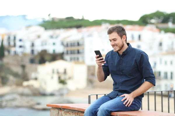 Hombre Feliz Sentado Una Cornisa Usando Teléfono Inteligente Una Ciudad —  Fotos de Stock