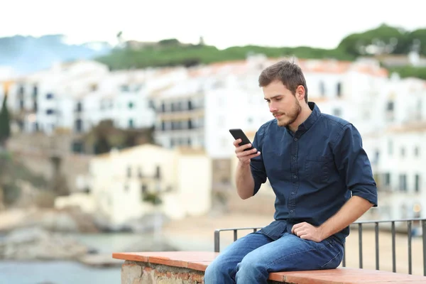 Serieuze Man Controleert Smart Phone Content Zittend Een Richel Vakantie — Stockfoto