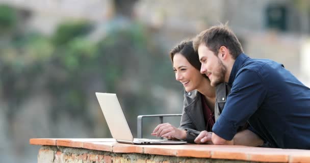 在农村公寓阳台上使用笔记本电脑搜索在线内容的快乐夫妇 — 图库视频影像