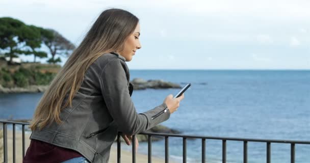 Ragazza Felice Utilizzando Uno Smartphone Balcone Con Mare Sullo Sfondo — Video Stock