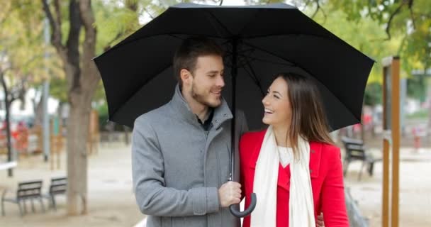 一对幸福的夫妇在雨中行走和说话的正面 — 图库视频影像