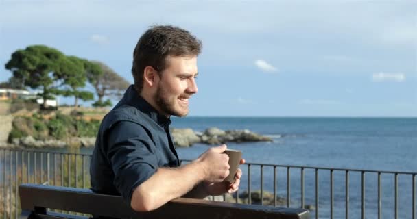 Szczęśliwy Człowiek Pije Kawę Oglądając Oceanu — Wideo stockowe