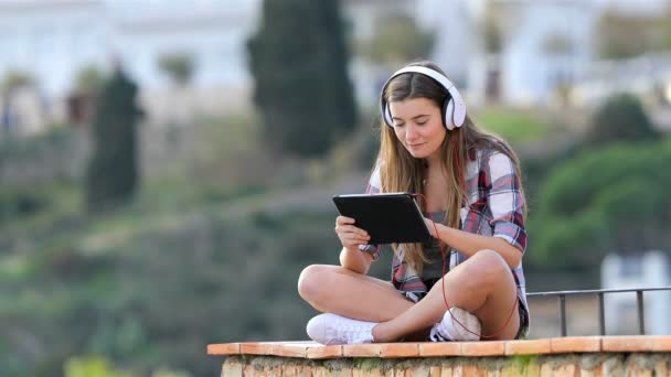 Feliz Adolescente Ouvindo Assistindo Conteúdo Mídia Tablet Sentado Uma Borda — Vídeo de Stock