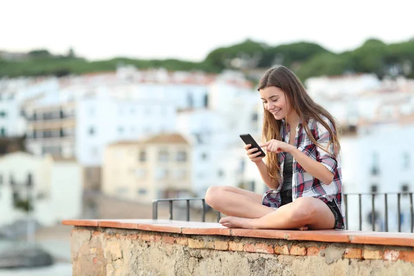 Menina Adolescente Feliz Usando Telefone Msrt Sentado Uma Borda Uma — Fotografia de Stock