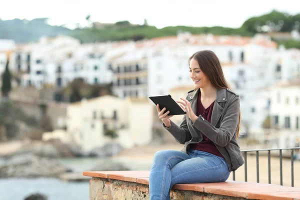 Happy Woman Using Tablet Sitting Ledge Coast Town Vacation — Stock Photo, Image