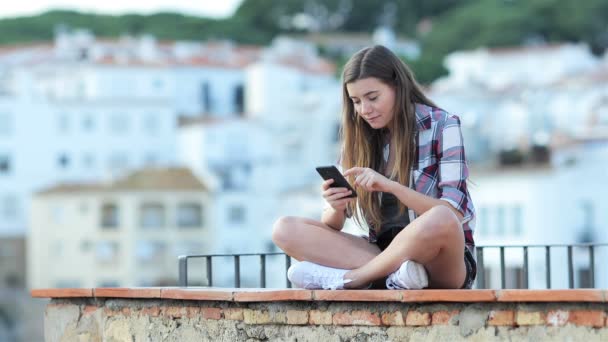 Zaskoczony Nastoletnie Dziewczyny Znajdowanie Treści Online Smartfonie Siedzi Półce Wakacjach — Wideo stockowe
