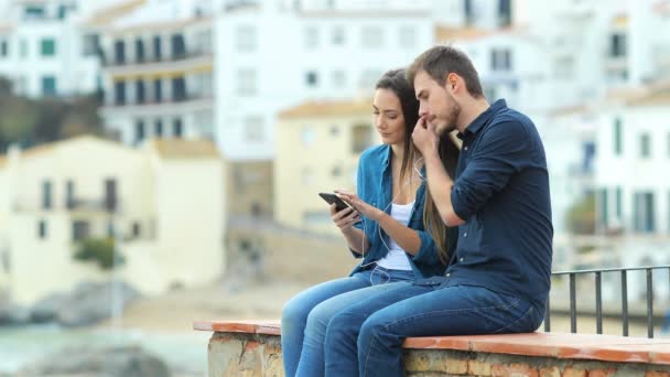 Casal Sério Compartilhando Música Respirando Livre Sentado Uma Borda Férias — Vídeo de Stock