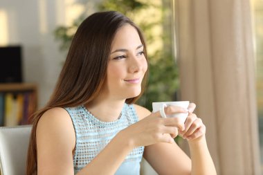 Mutlu kadın yüzüne kahve fincanı evde tutan rahatlatıcı