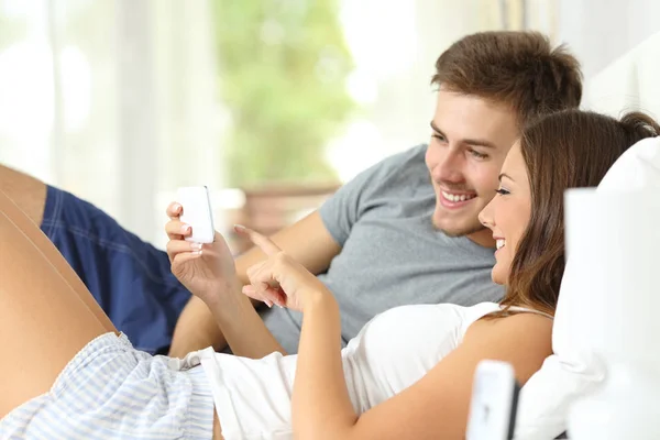 Akıllı Telefon Medya Içeriği Evde Kontrol Yatakta Mutlu Çift — Stok fotoğraf