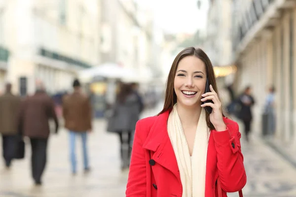 一个穿着红色衣服走路的快乐女性在街上打电话的正面肖像 — 图库照片