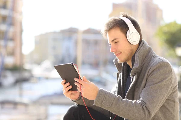 Serieuze Man Kijkend Luisterend Media Een Tablet Zittend Straat Van — Stockfoto