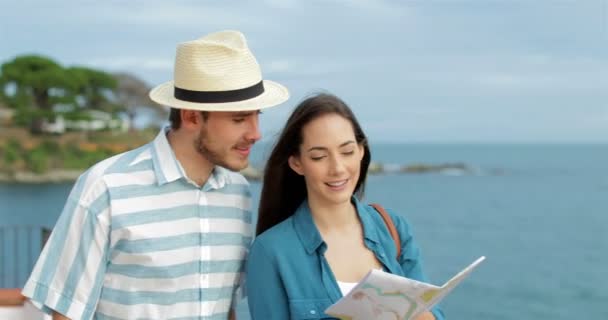 Счастливая Пара Туристов Проверяет Карту Прогуливаясь Пляжу — стоковое видео