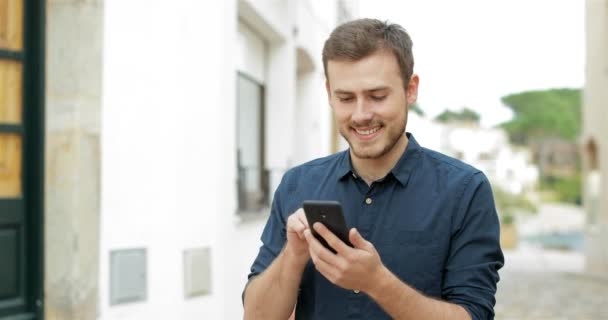 Homem Feliz Caminhando Direção Câmera Navegando Conteúdo Celular Rua — Vídeo de Stock