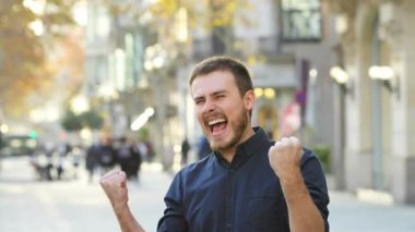 Heyecanlı adam başarı sokakta kutlama silah yükseltme