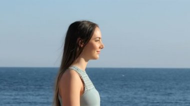 Sahilde temiz hava alan mutlu bir kadının portresi.
