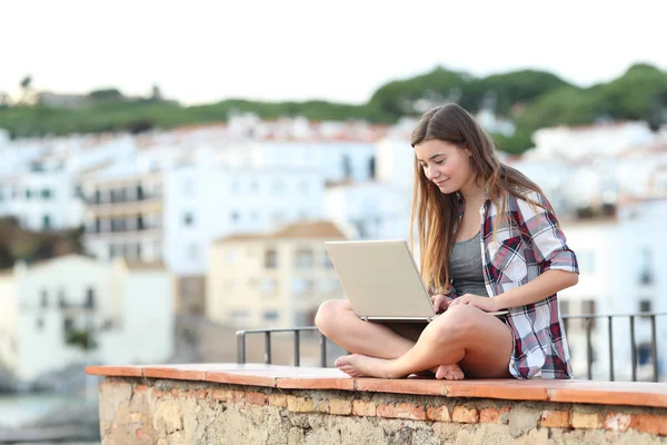 Adolescente Feliz Usando Portátil Sentado Una Cornisa Una Ciudad Costera —  Fotos de Stock