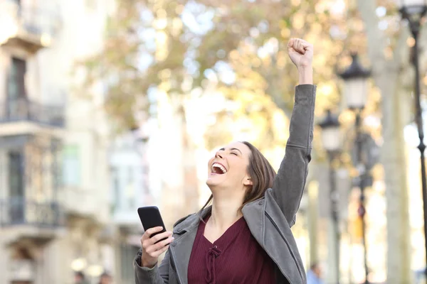 Retrato Una Mujer Excitada Sosteniendo Teléfono Inteligente Levantando Brazo Calle —  Fotos de Stock