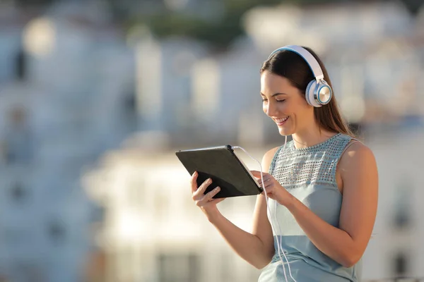 Mutlu Kadın Litening Müzik Günbatımında Bir Kasabada Tablet Içeriğini Görüntülemek — Stok fotoğraf