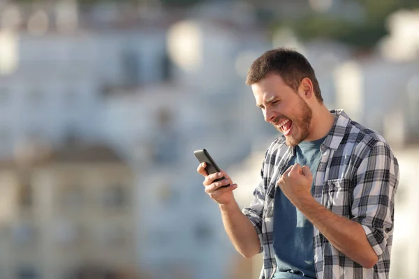 Heyecanlı Adam Akıllı Telefon Içeriği Bir Kasabada Günbatımında Kontrol — Stok fotoğraf