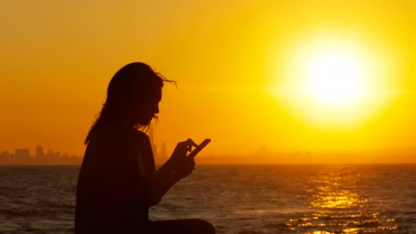 Silhueta Uma Mulher Animada Pôr Sol Verificando Notícias Telefônicas Praia — Vídeo de Stock