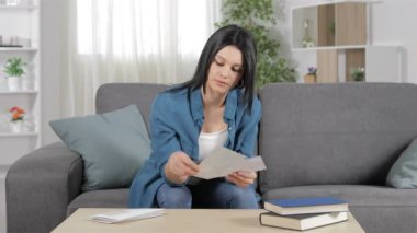 Hayran kadın oturma odasında evde bir kanepede oturan bir mektup üzerinde iyi haber okuma