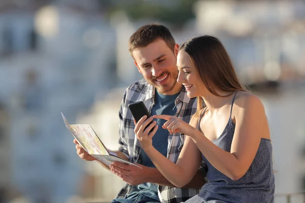 Gelukkige Paar Toeristen Vergelijken Smartphone Inhoud Papieren Kaart Een Stad — Stockfoto