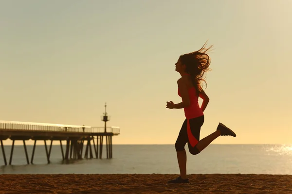 日の出 ビーチを走る女性の側ビュー肖像 — ストック写真