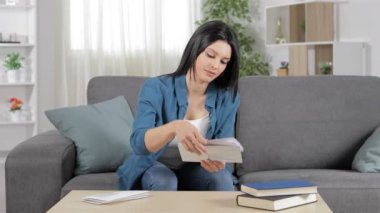 Mutlu kadın evde bir kanepede oturan bir mektup okuma