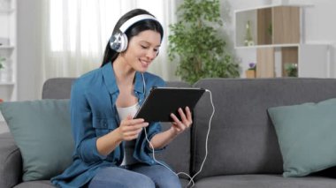 Mutlu kadın evde bir kanepede oturan tablet bir videocall sahip