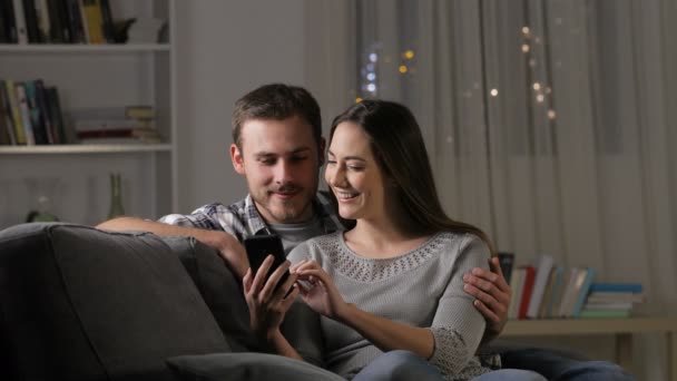 Pareja Emocionada Encontrando Increíble Contenido Teléfono Inteligente Sentado Sofá Sala — Vídeo de stock