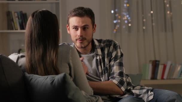 愉快的夫妇或朋友谈论坐在沙发上晚上在家 — 图库视频影像