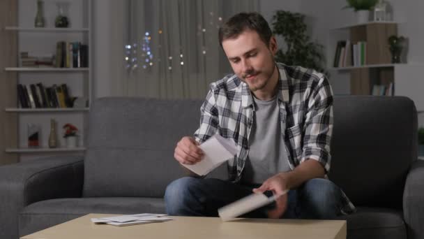 Opgewonden Man Leest Goed Nieuws Brief Zittend Een Bank Huiskamer — Stockvideo