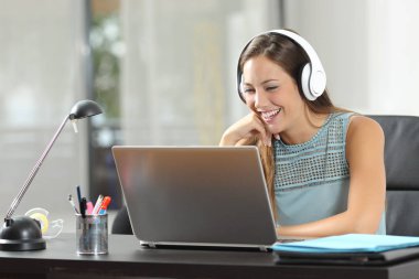 Mutlu kız evde bir odada bir masa üstünde laptop medya içeriğine izlerken