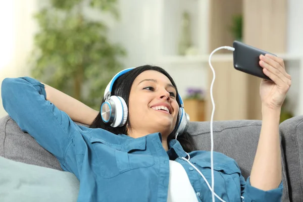 Mujer Feliz Viendo Escuchando Videos Teléfono Inteligente Sentado Sofá Sala — Foto de Stock