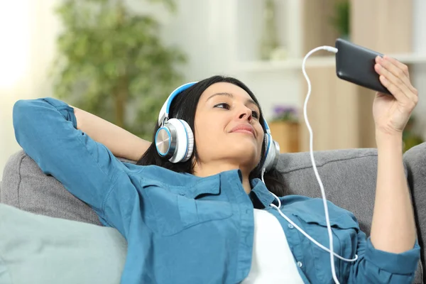 Zrelaksowana Kobieta Ogląda Filmy Smartfonie Siedząc Kanapie Salonie Domu — Zdjęcie stockowe