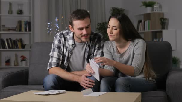 Pareja Sorprendida Recibiendo Buenas Noticias Una Carta Sentada Sofá Noche — Vídeos de Stock