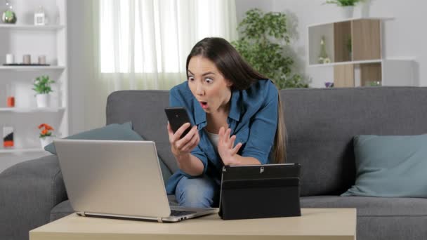 Mujer Sorprendida Usando Múltiples Dispositivos Sentados Sofá Casa — Vídeos de Stock