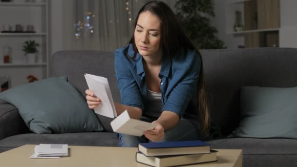 自宅のリビング ルームでソファの上に座っている夜に手紙を読んで怒っている女性 — ストック動画