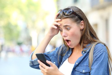 Şok olmuş genç bir kız akıllı telefonu kontrol ediyor. Sokakta hata içeriğini keşfediyor.