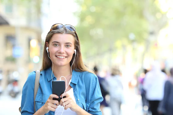 Menina Adolescente Feliz Olhando Para Câmera Ouvindo Música Telefone Inteligente — Fotografia de Stock