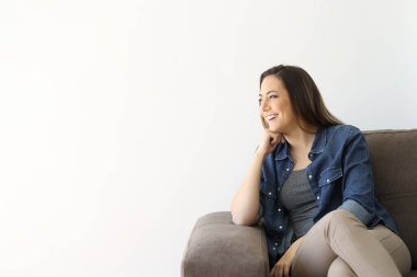 İzole edilmiş beyaz arka planda bir koltukta oturan mutlu ev sahibi.