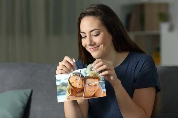 Meisje Herbouwt Een Gebroken Foto Verzoening Zittend Een Bank Woonkamer — Stockfoto